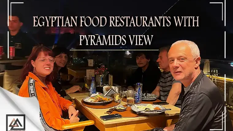 tourists dining at an egyptian restaurant near the giza pyramids with a night view
